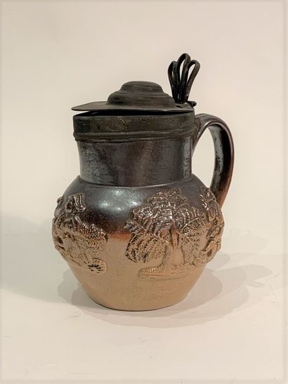 null Enamelled stoneware pitcher decorated with vine leaves and mills and drinkers....