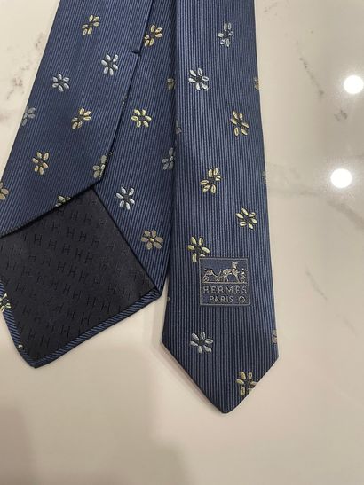 null HERMES PARIS 

Cravate en soie bleu et motifs de fleurettes 

Usures, tâche...