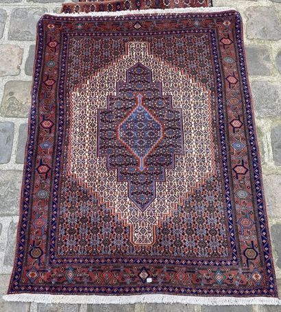 null Set of three carpets, one decorated with a central medallion on a red background...