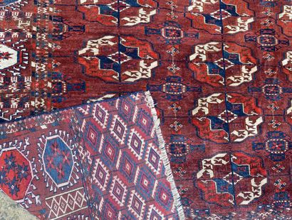 null TAPIS BOUKHARA en laine à décor de guhls sur fond rouge. 

274 x 205 cm