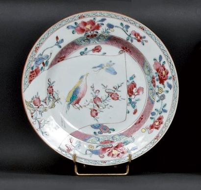 CHINE Assiette à décor polychrome des émaux de la famille rose au centre d'un oiseau...