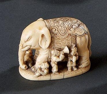 null Netsuke en ivoire à patine jaune, enfants jouant près d'un éléphant. Japon,...