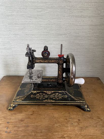 null Wrought iron sewing machine with painted gilded decoration of friezes and interlacing....