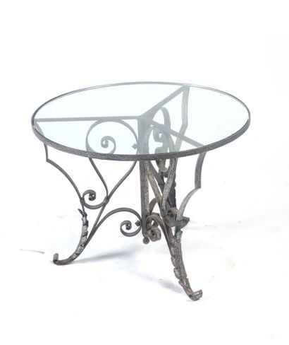 null Circular LOW TABLE, the tripod base in wrought iron forming scrolls underlined...
