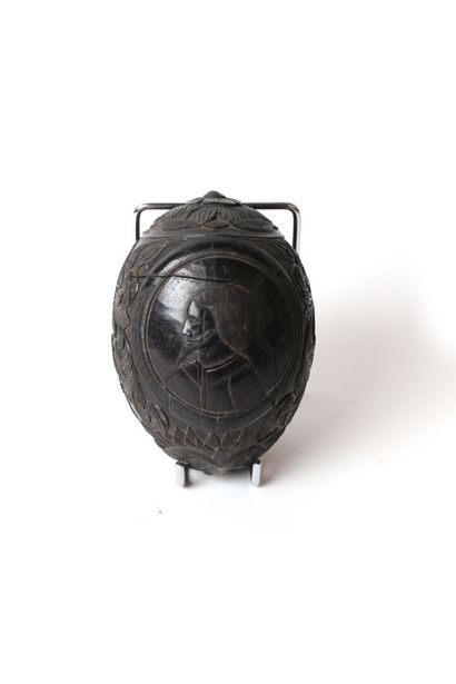 null COROZO NUT carved with two portraits in a medallion surrounded by nets in a...
