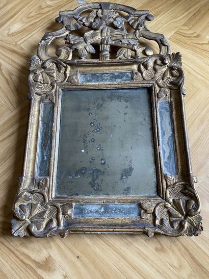 null SMALL MIRROR with a carved and gilded wood and stucco frame, the pediment decorated...