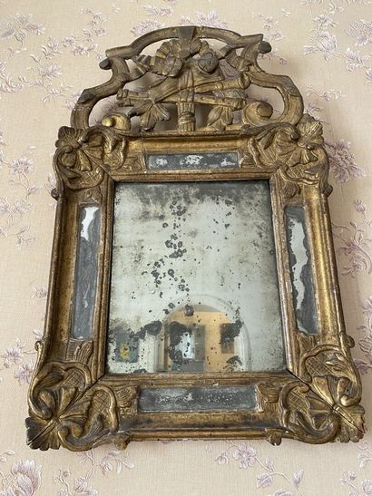 null SMALL MIRROR with a carved and gilded wood and stucco frame, the pediment decorated...