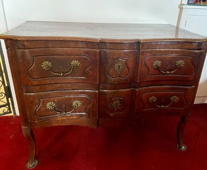 null A crossbow-shaped COMMODE in molded walnut opening to two drawers, resting on...