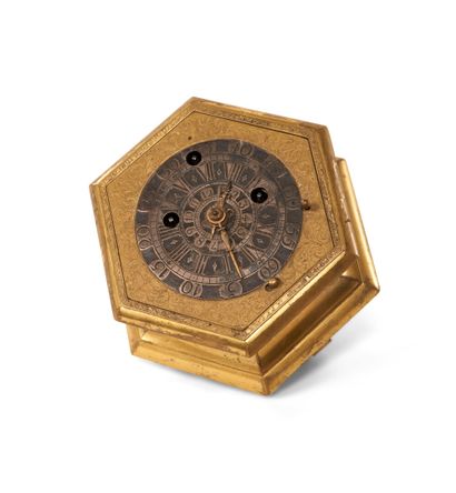 null A bronze and engraved brass table clock of hexagonal form, decorated with foliage...