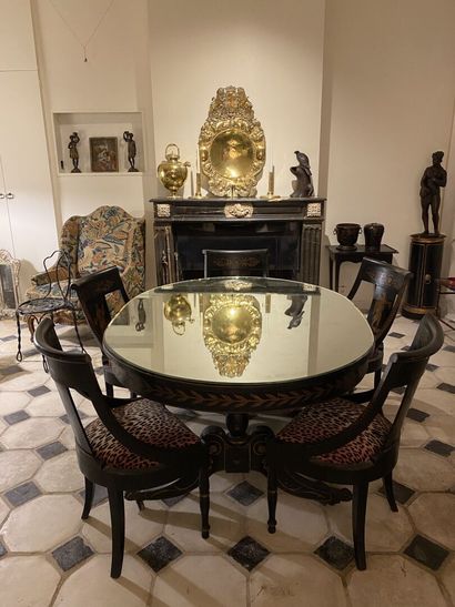 null Blackened and gilded wood oval-shaped table with two side legs joined by a brace...