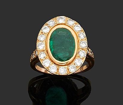 null Yellow gold ring 750 thousandths decorated in the center of an oval emerald...