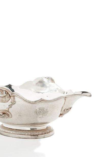 null Silver sauceboat of oval form posing on pedestal godronné, the handles foliated...