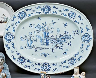 NEVERS OU ROUEN Grand plat ovale décoré en camaïeu bleu d'objets précieux et de vases...
