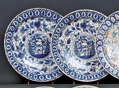 DELFT Paire d'assiettes rondes décorées en camaïeu bleu d'un angelot dans un médaillon...