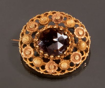 null Brooch in yellow gold 750 thousandths decorated in the center with a garnet...