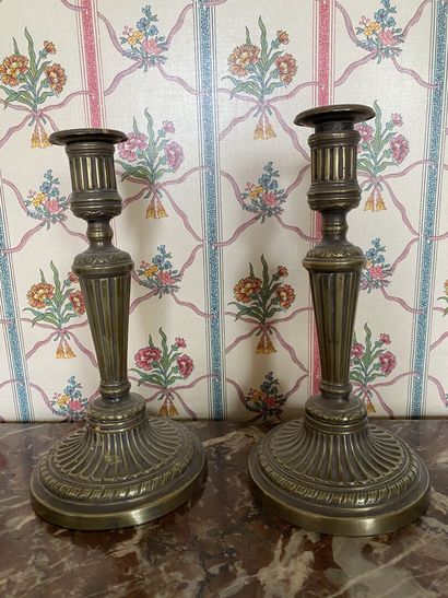 null PAIR OF FLAMBEAUX in gilt bronze with fluted shaft and round base with ribboned...