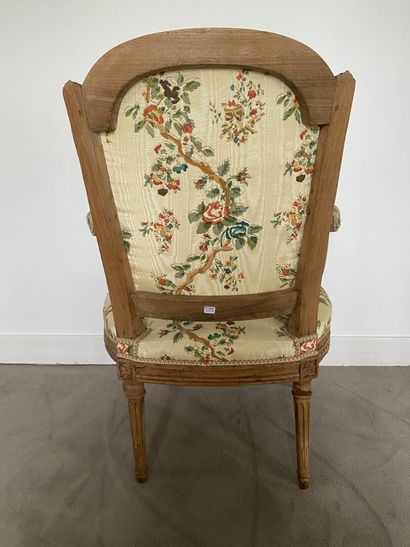 null An armchair in molded and carved natural wood, with a "chapeau de gendarme"...