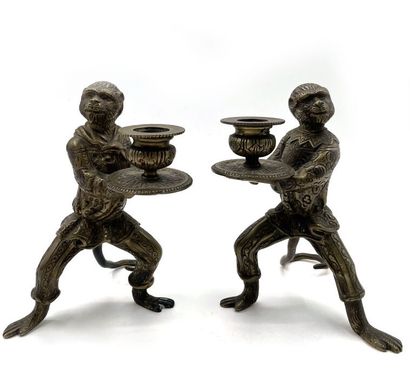 null PAIRE DE BOUGEOIRS en bronze patiné figurant deux singes serviteurs portant...