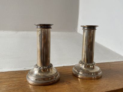 null TWO SMALL CANDLESTICKS in silver-plated metal, the circular base decorated with...