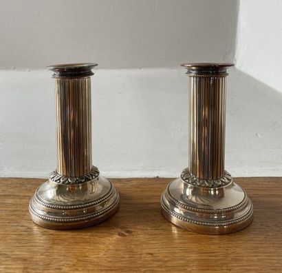 null TWO SMALL CANDLESTICKS in silver-plated metal, the circular base decorated with...