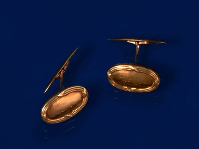null Pair of cufflinks in 750 thousandths yellow gold, the oval-shaped ends engraved...