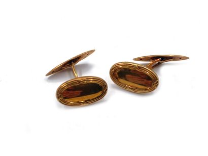 null Pair of cufflinks in 750 thousandths yellow gold, the oval-shaped ends engraved...