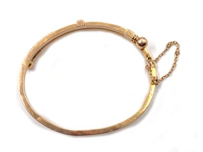 null Rigid, opening bracelet in yellow gold 750 thousandths, the center adorned with...