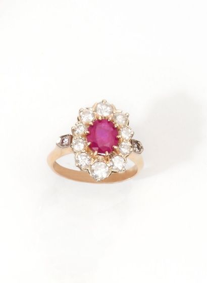 null Ring set with a central oval ruby in a surround of round diamonds.
Finger size:...