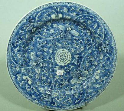 CHINE Plat rond à fond bleu décoré de fleurs traitées en enroulement. XVIIIè siècle....