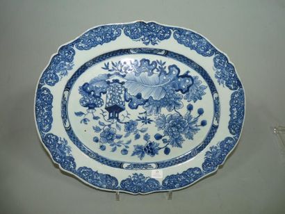 CHINE Plat ovale à bord contourné, décoré en bleu sous couverte de deux vases fleuris,...
