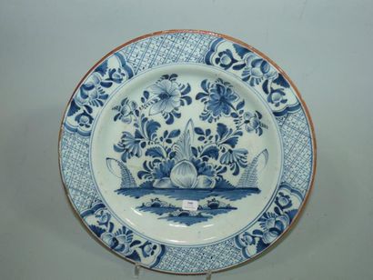 DELFT Plat rond décoré en bleu de fleurs encadrées de quadrillage. XVIIIè siècle....