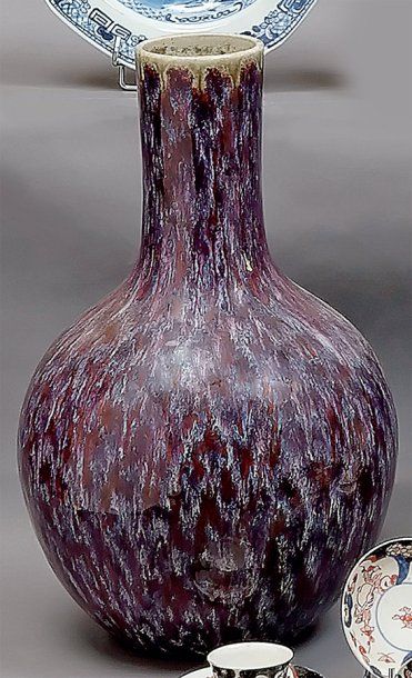 null CHINE - Vase bouteille de forme balustre à couverte émaillée rouge violacé....