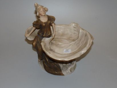 ROYAL DUX Coupe en porcelaine figurant une jeune femme assise sur une feuille. Emaux...