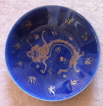 CHINE Assiette en porcelaine à fond bleu à décor en or d'un dragon. XIXe siècle....