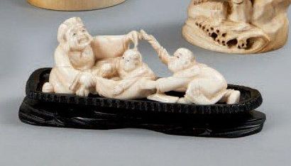 JAPON - Epoque MEIJI (1868 - 1912) Okimono en ivoire, personnage avec deux enfants....