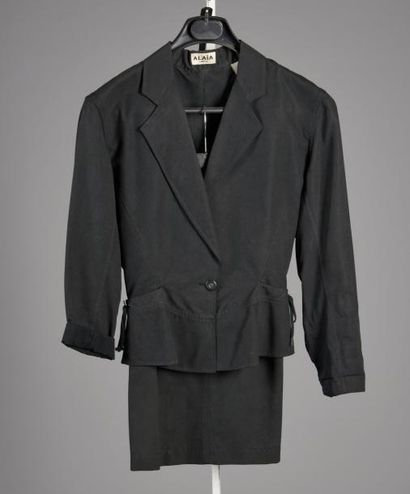 ALAÏA Tailleur toile de coton noir, composé d'une veste cintrée avec basque, col...