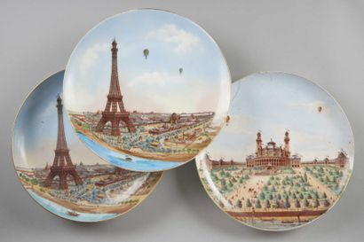 PARIS Trois grand plats en porcelaine à décor de l'Exposition Universelle, deux figurant...