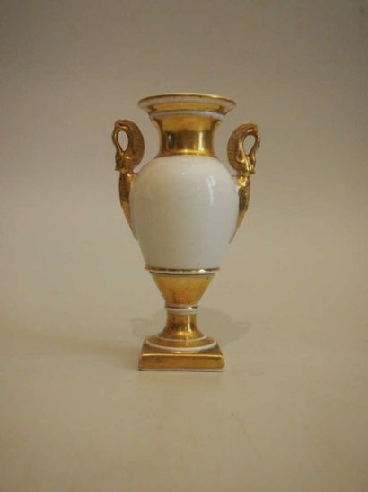 PARIS Petit vase Médicis à deux anses en forme de dauphins, décor en blanc et or....