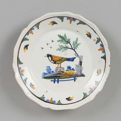 NEVERS Assiette à bord contourné à décor polychrome d'un oiseau sur un tertre. XIXème...