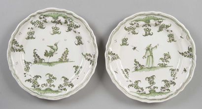MOUSTIERS Deux assiettes à bordures contournées décorées en camaïeu vert de grotesques...