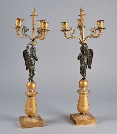 null PAIRE DE CANDÉLABRES à quatre lumières soutenues par des amours en bronze à...