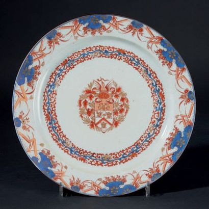 CHINE Plat rond en porcelaine à décor bleu, rouge et or dit Imari au centre d'armoiries...