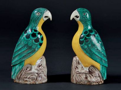 CHINE Paire de perroquets en porcelaine émaillés vert et jaune perchés sur un rocher....