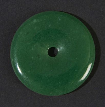 CHINE-XXe siècle Pendentif en forme de "bi" en jadéite verte. Diam. 4,8 cm.