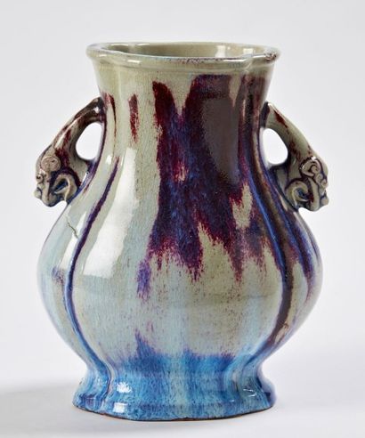 CHINE Vase balustre en porcelaine à deux anses en forme de chimères à fond bleu flammé....