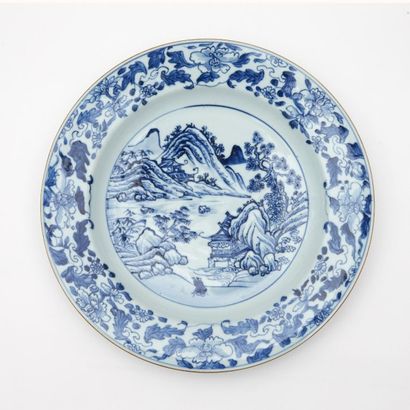 CHINE Plat rond en porcelaine à décor en bleu sous couverte d'un paysage lacustre...