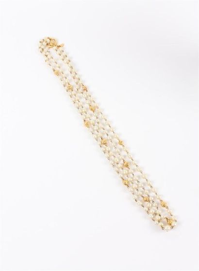 CHANEL Double sautoir composé de perles en métal doré martelé et de perles blanches....