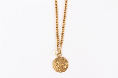 CHANEL Sautoir chaîne en métal doré, retenant un médaillon martelé figurant un lion...