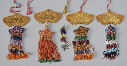 VIETNAM - XXE SIÈCLE 
Quatre décorations en métal doré en forme de qin, à décor en...