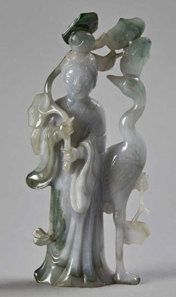 CHINE - XXe siècle 
Femme debout en serpentine céladon tenant de la main droite une...